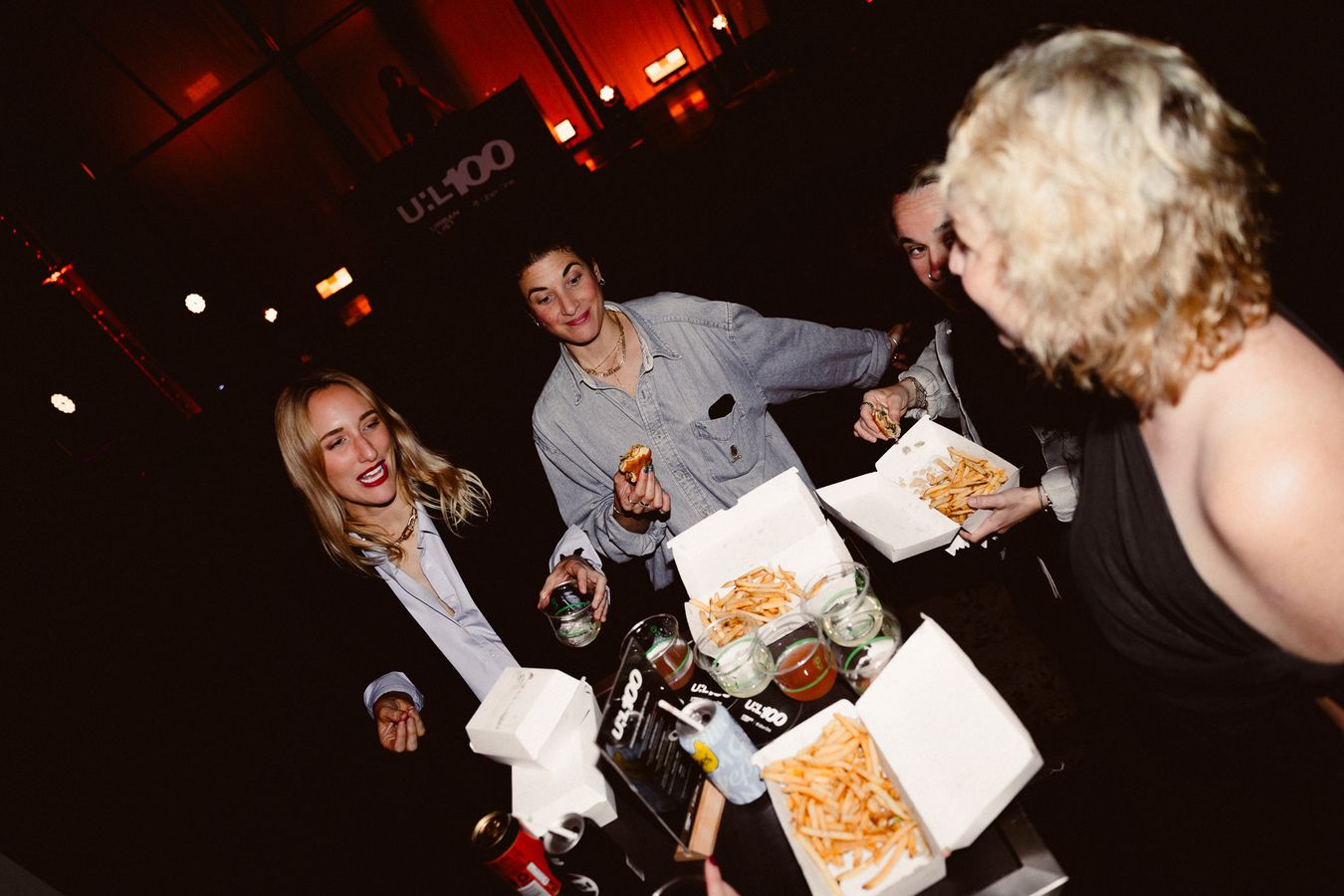 Guests sharing fries and burgers at the Urban List 100 party